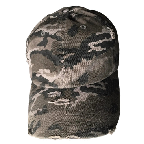 A distressed baseball cap with a gray, black, and beige camouflage pattern, featuring ripped details on the brim.