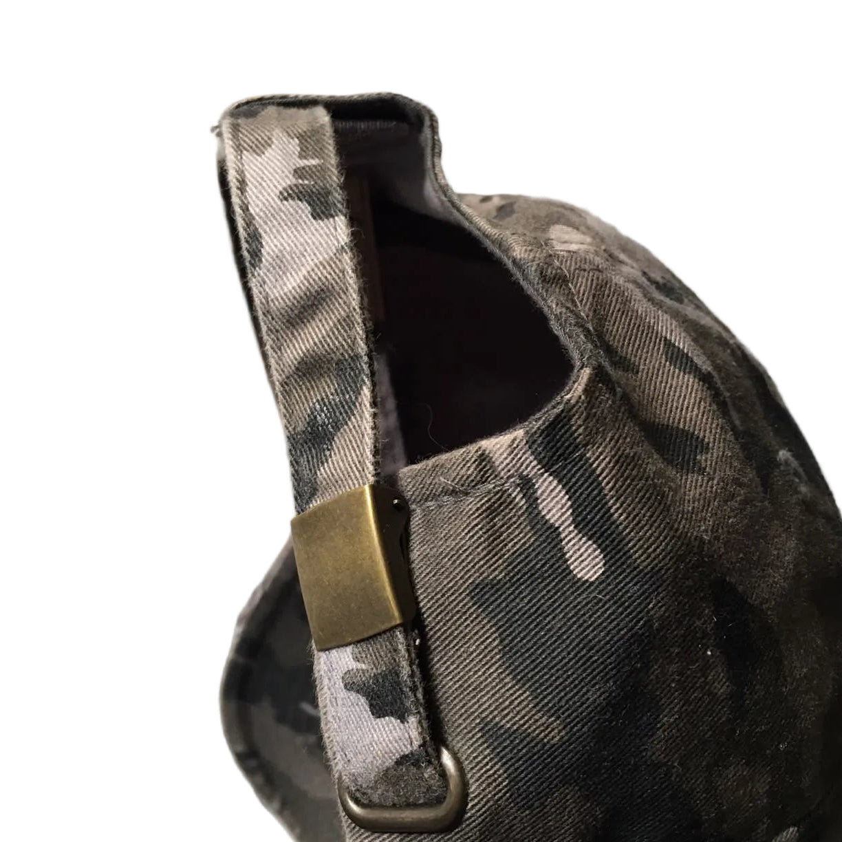 A close-up of a dark gray and black camouflage baseball cap with a metal buckle strap.
