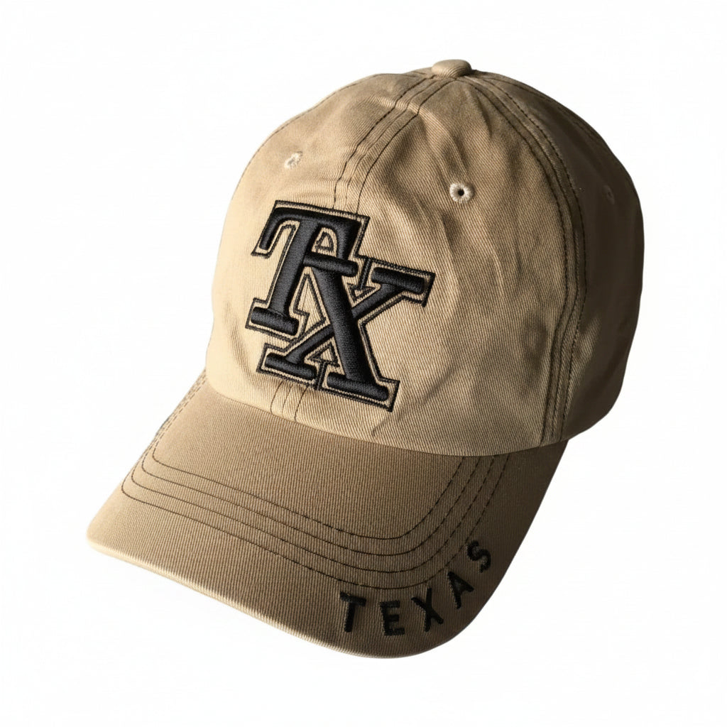 A beige baseball cap featuring an embroidered black and white 'TX' logo on the front and 'TEXAS' stitched on the brim.
